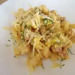 Pyszna carbonara z cukinią, makaronem, boczkiem i parmezanem, posypana świeżym koperkiem.