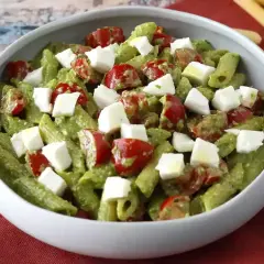 Penne z zielonym pesto, pomidorkami koktajlowymi i kostkami mozzarelli. Idealna sałatka z rukolą na letni obiad.