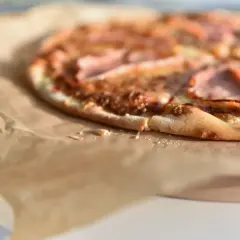 Apetyczna pizza na papierze. Zastanawiasz się, ile waży kawałek pizzy? Ten wygląda na idealny na szybką przekąskę.