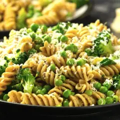 Pyszny makaron z warzywami: zielony groszek i brokuły, posypany startym parmezanem. Idealny lekki posiłek.