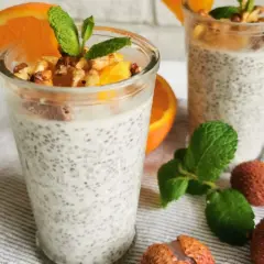 Pudding chia z pomarańczą i orzechami, ozdobiony miętą i owocami lychee.