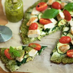 Pyszna pizza na spodzie z brokuła z kurczakiem, cukinią, pomidorkami i pesto.