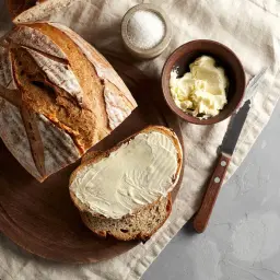 Chleb na drożdżach, świeżo upieczony, z masłem i solą. Idealny przepis na pyszne śniadanie.