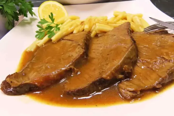 Tradycyjne bitki wołowe w sosie, podane z makaronem i plasterkiem cytryny. Pyszny przepis na obiad.