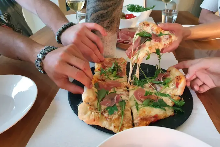 Pieczenie pizzy na kamieniu zakończone sukcesem! Rozciągający się ser i rukola kuszą.
