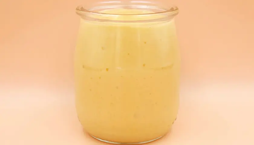 Gęsty, kremowy mango lassi w szklanym słoiku, gotowy do orzeźwiającego łyku.