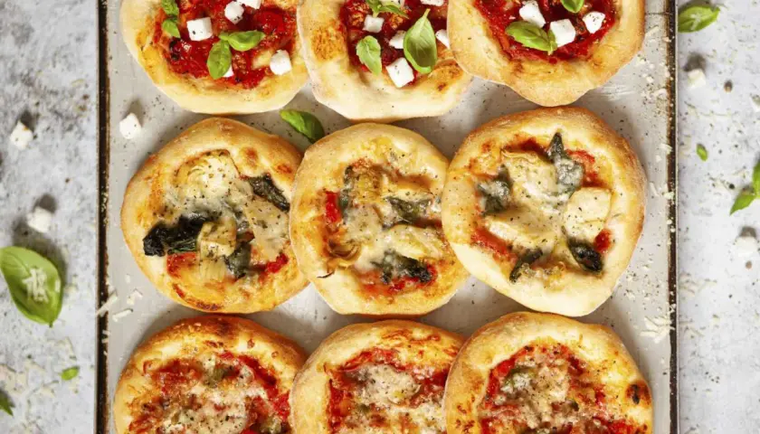 Mini pizze z mozzarellą, bazylią, pomidorami, karczochami i szpinakiem. Wiele opcji, co można dać na pizzę!