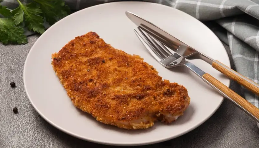 Złocisty kotlet schabowy na talerzu, gotowy do zjedzenia. Zastanawiasz się nad kotlet schabowy kcal?