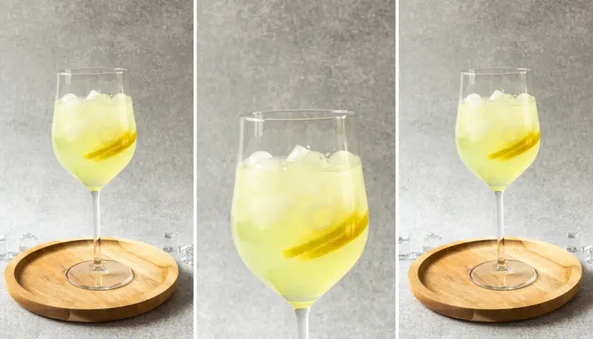 Orzeźwiający drink z limoncello, lodem i plasterkami cytryny, podany na drewnianej podstawce. Idealny na letnie popołudnie.