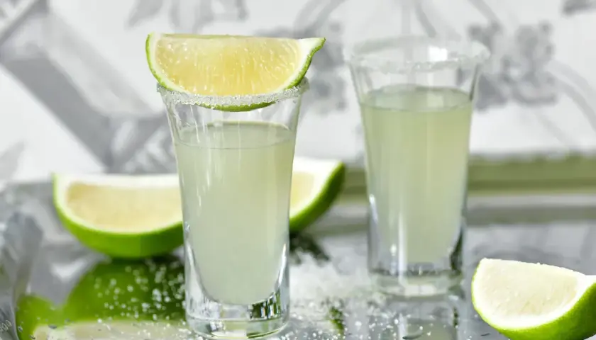 Dwa kieliszki z drinkiem Kamikaze, ozdobione cukrem i limonką. Zastanawiasz się, kamikaze drink ile procent?