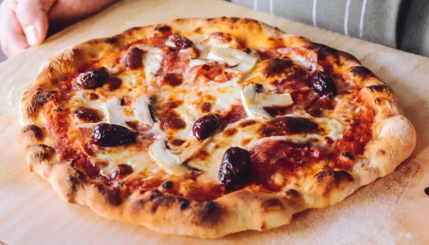 Idealna pizza na kamieniu: chrupiące ciasto, ciągnący ser, oliwki i pieczarki. Sekret jak piec pizze na kamieniu tkwi w wysokiej temperaturze.