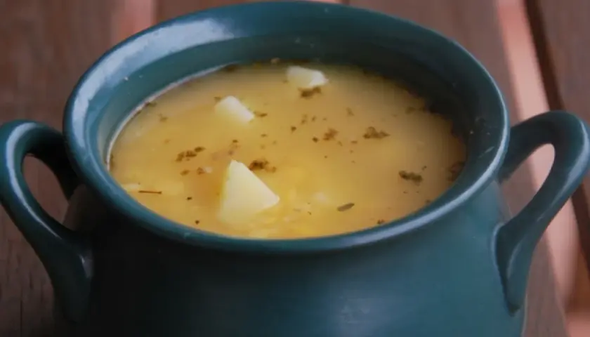 Aksamitna zupa grochowa, przepis babci, w ciemnozielonej wazie z ziemniakami i ziołami.