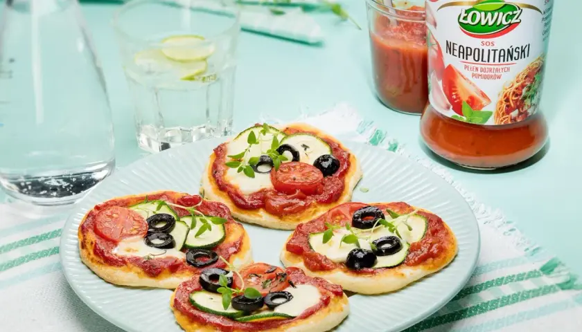 Pizzerinki z ciasta do pizzy, z sosem neapolitańskim Łowicz, mozzarellą, cukinią, oliwkami i pomidorkami.