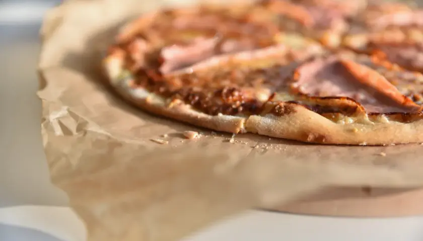 Apetyczna pizza na papierze. Zastanawiasz się, ile waży kawałek pizzy? Ten wygląda na idealny na szybką przekąskę.
