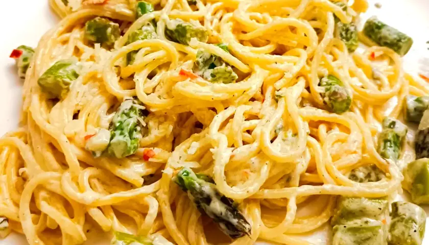 Pyszne spaghetti ze szparagami w kremowym sosie, posypane parmezanem. Idealne danie na wiosnę.