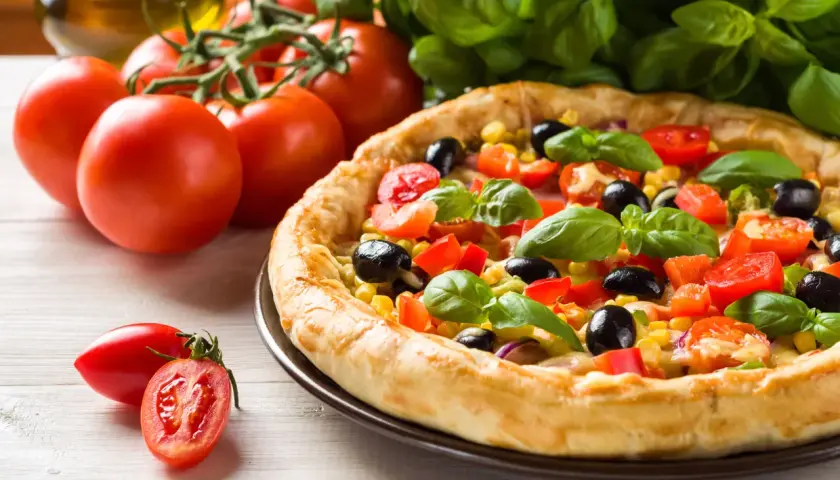 Pyszna pizza Giusseppe z pomidorami, oliwkami i kukurydzą, świeża bazylia. Idealna na 200 stopni Celsjusza.