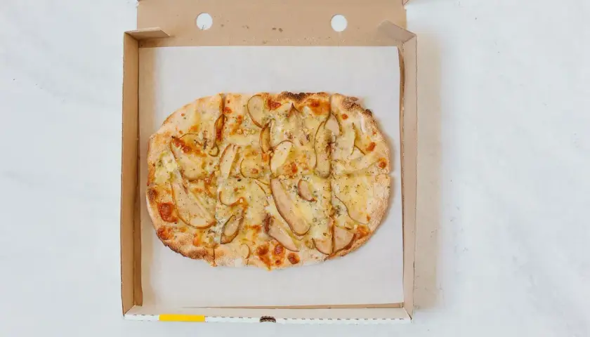 Pyszna pizza z gruszką i serem w pudełku. Czy pizza to fast food? Ta wygląda na wykwintną!