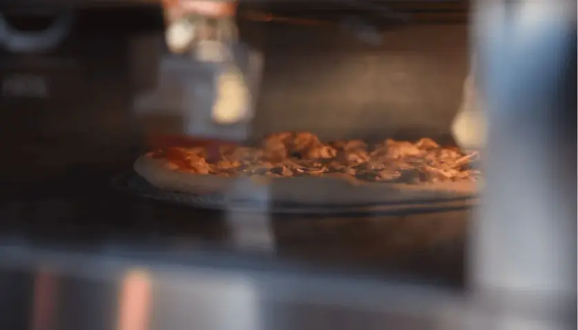 Pizza piecze się w wysokiej temperaturze, by uzyskać chrupiący spód i idealnie roztopiony ser.