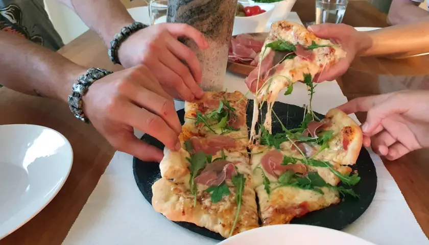 Pieczenie pizzy na kamieniu zakończone sukcesem! Rozciągający się ser i rukola kuszą.