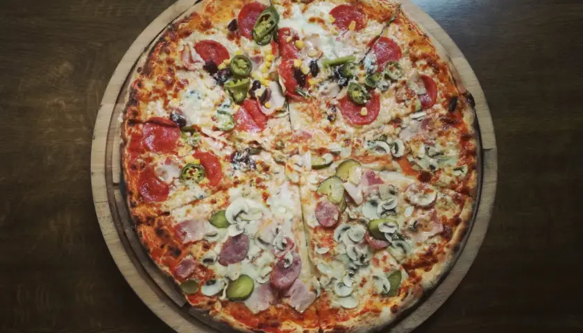 Pyszna pizza włoska z salami, pieczarkami, korniszonami i kukurydzą. Idealna na wieczór, choć warto pamiętać o jej kcal.