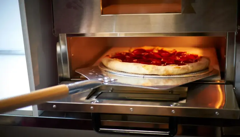Pizza z pepperoni wjeżdża do pieca z termoobiegiem. Idealna do chrupiącego ciasta!
