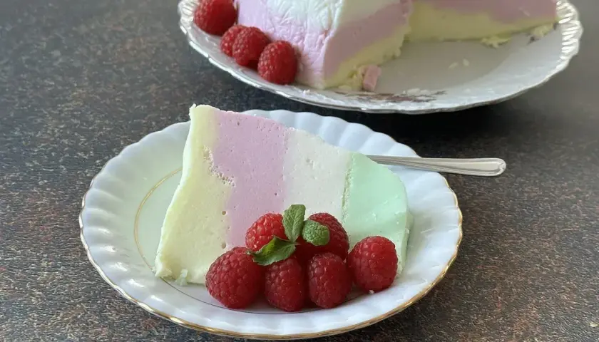 Pianka z galaretki i jogurtu w pastelowych kolorach, udekorowana malinami.