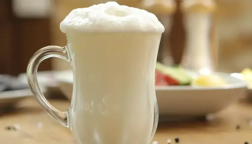 Puszysty ayran w szklance, idealny napój na upalne dni. Czy wiesz, ayran co to? To orzeźwiający napój jogurtowy.