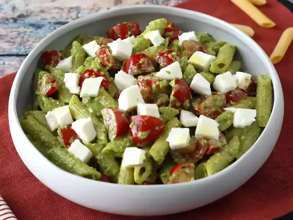 Penne z zielonym pesto, pomidorkami koktajlowymi i kostkami mozzarelli. Idealna sałatka z rukolą na letni obiad.
