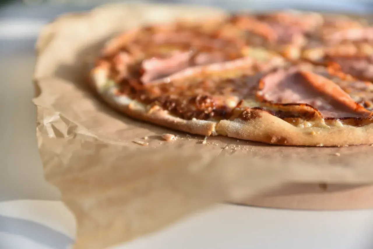 Apetyczna pizza na papierze. Zastanawiasz się, ile waży kawałek pizzy? Ten wygląda na idealny na szybką przekąskę.