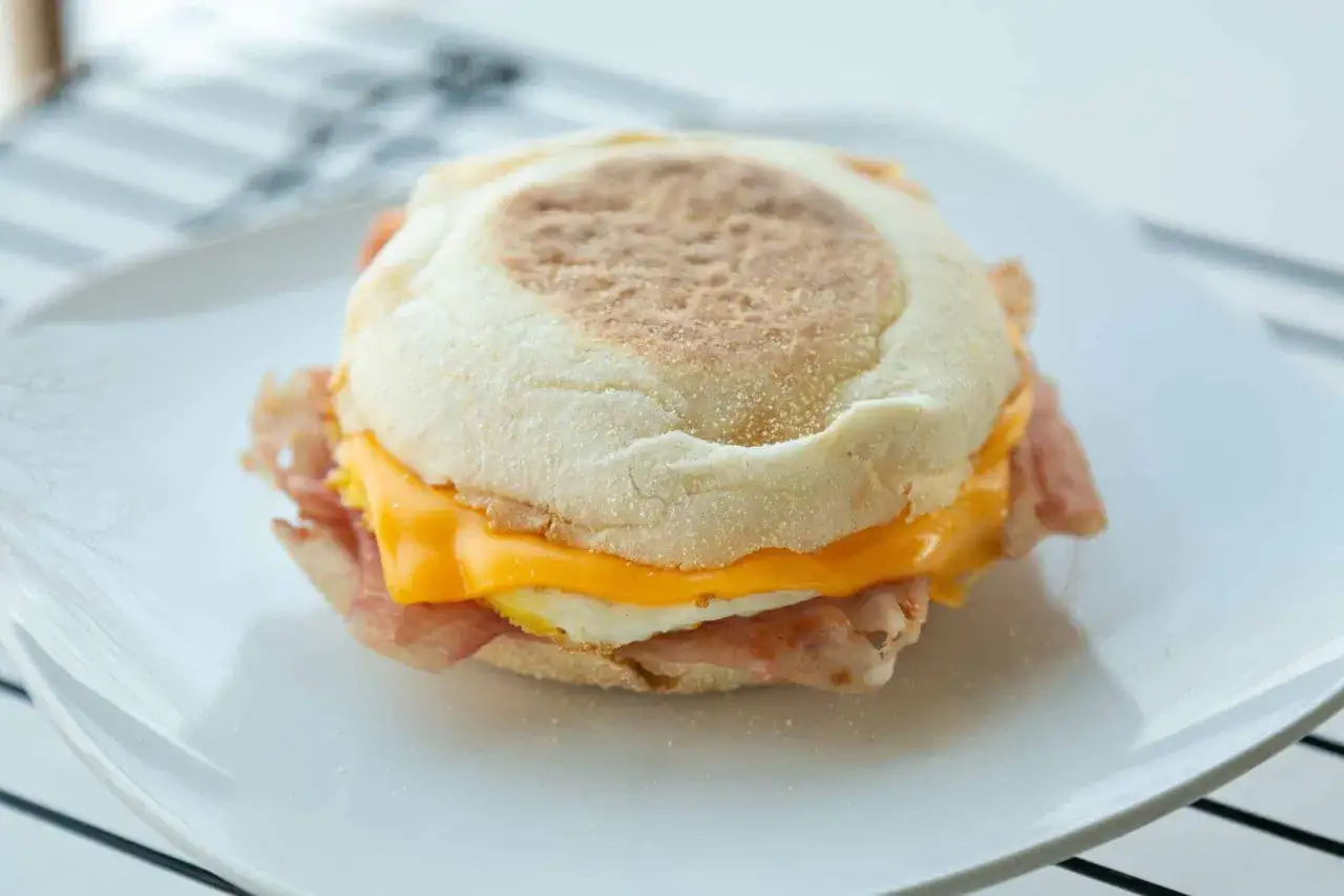 Pyszny croque madame na talerzu: bułka, jajko sadzone, ser i szynka.