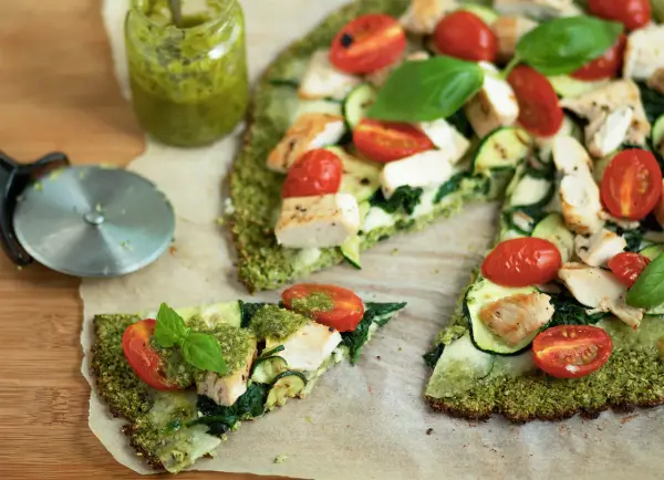 Pyszna pizza na spodzie z brokuła z kurczakiem, cukinią, pomidorkami i pesto.