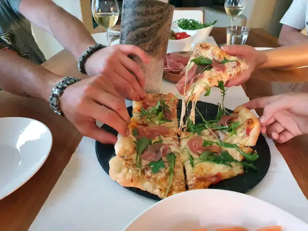Pieczenie pizzy na kamieniu zakończone sukcesem! Rozciągający się ser i rukola kuszą.